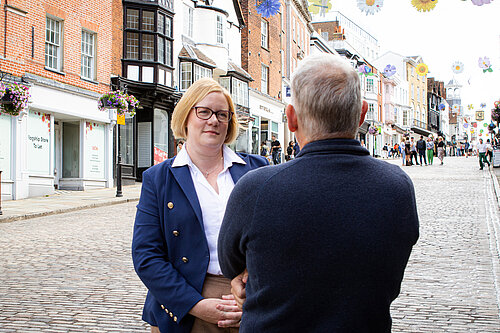 Zöe Franklin listening to a resident on Guildford High Street